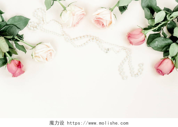 在白色的地面上散落着一串珍珠项链和几朵玫瑰花在明亮的背景下欣赏美丽玫瑰和珍珠项链的美景